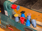 Roloc-style lathe sander adapters in red, blue and gray on the lathe bed with a flap disc mounted